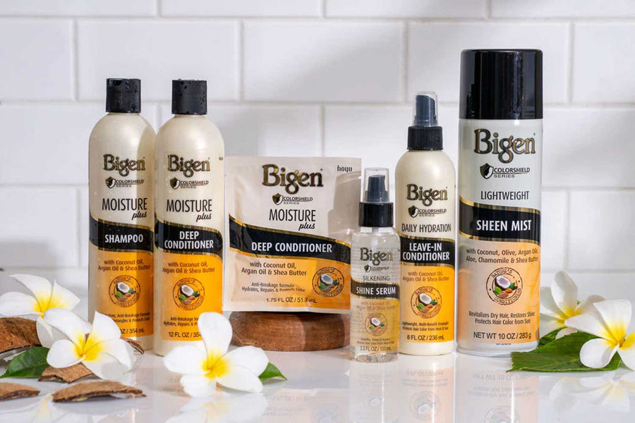 Collection of Bigen hair care products on a white surface with flowers.